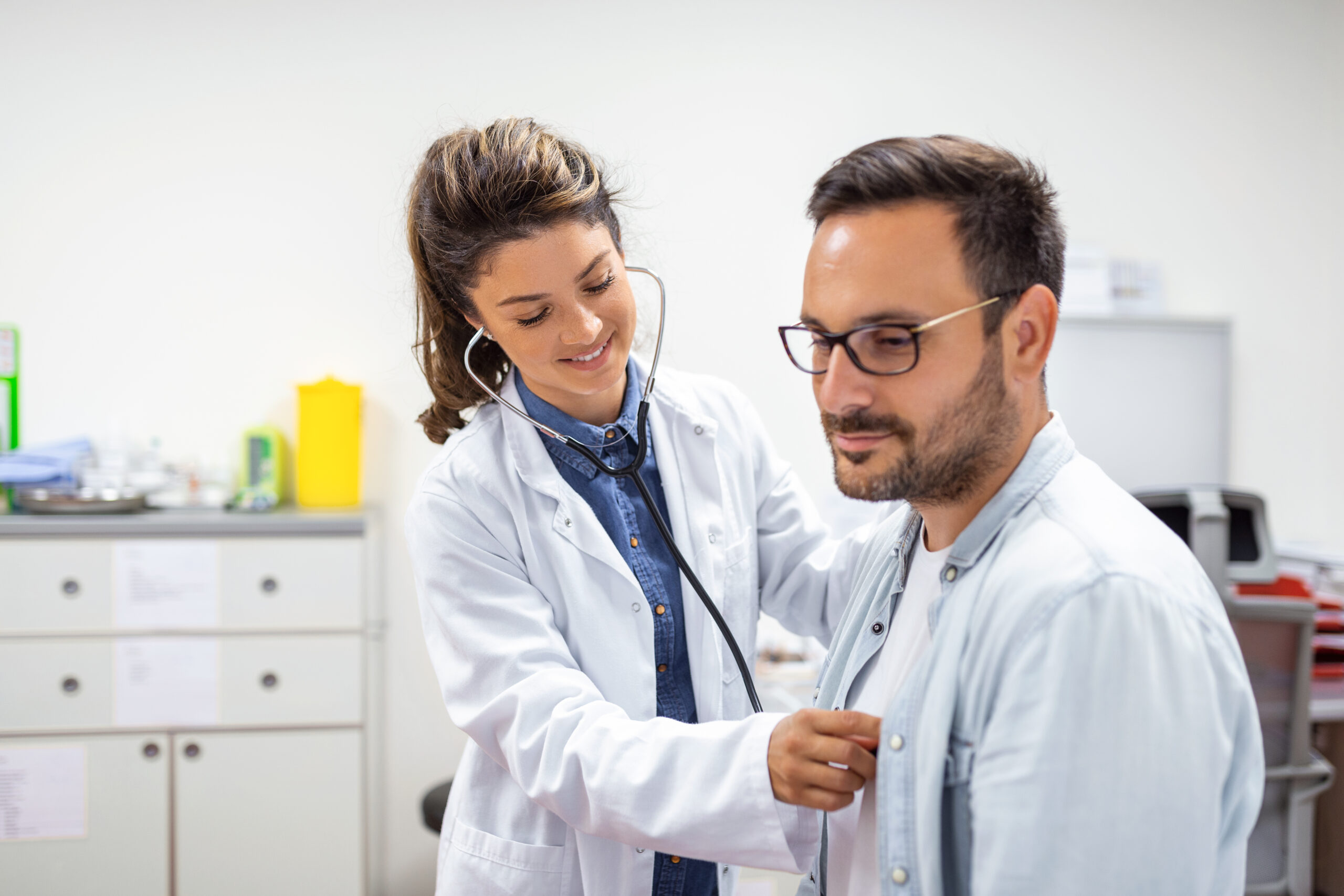 young-doctor-is-using-stethoscope-listen-heartbeat-patient-shot-female-doctor-giving-male-patient-check-up-scaled.jpg